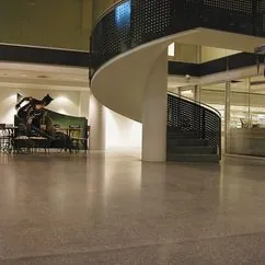 Åpen foajé med buet trapp og slipt betonggulv